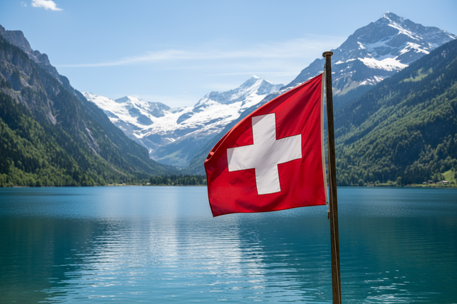 Wehende Schweizerfahne mit See im Hintergrund